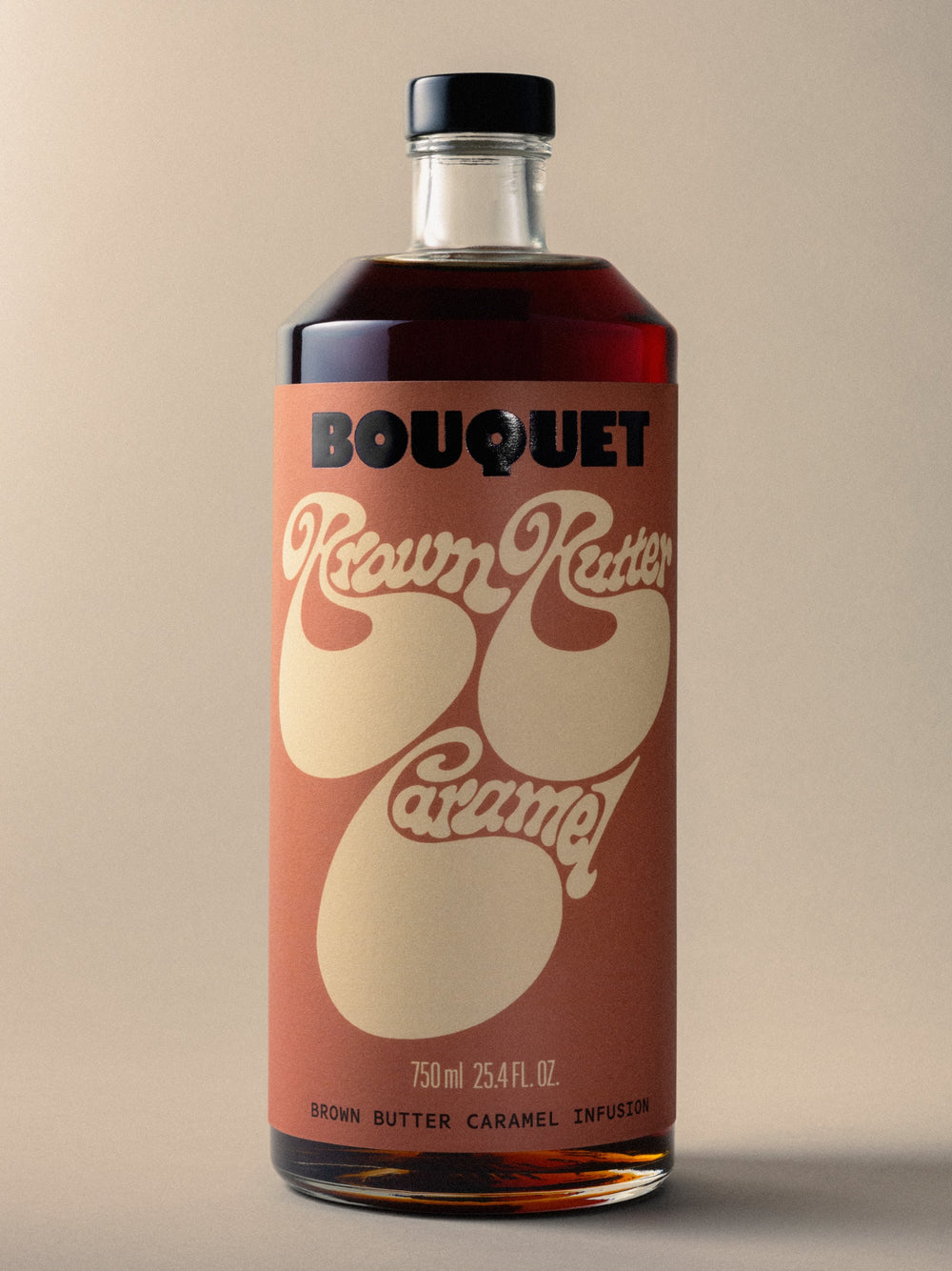 Bottle of Bouquet Brown Butter Caramel infusion with a rich brown label, bold black BOUQUET logo, and large cream colored graphic. Text reads ‘Brown Butter Caramel’ in groovy cream color script. 750 ml (25.4 fl oz).
