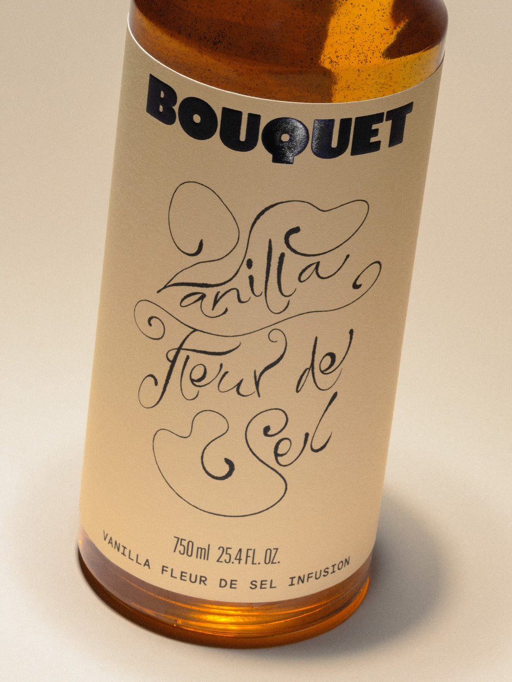 Bottle of Bouquet Vanilla Fleur de Sel infusion with a cream colored label, bold black BOUQUET logo, and large black graphic. Text reads ‘Vanilla Fleur de Sel’ in black. 750 ml (25.4 fl oz).