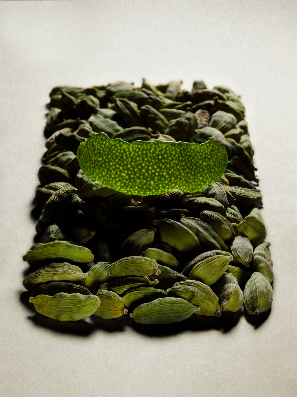 Clear glass of Matcha, backlit, with pale green background.